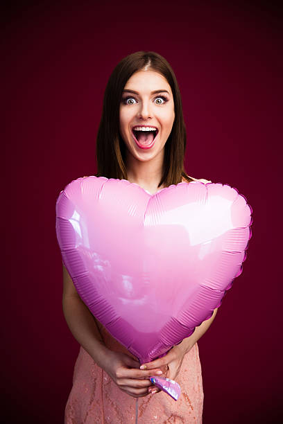 istock Surprised woman holding heart shaped balloon 469927454