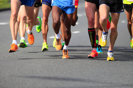 Rotterdam, Netherlands - April 12, 2015; legs and feet of athletes on sport shoes of brands like Saucony, Brooks and Adididas competing in the Rotterdam Marathon 2015.