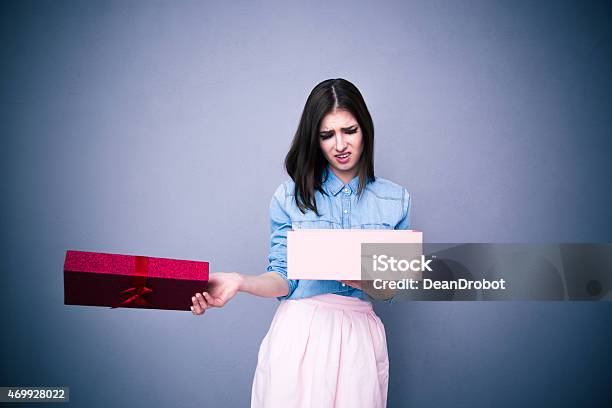 Dissatisfied Woman Opening Gift Stock Photo - Download Image Now - Disappointment, Rudeness, Christmas Present