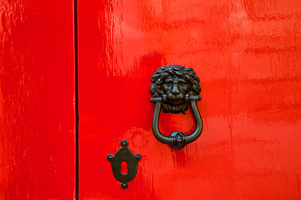 istock Old red door with lion head metal knockers 469928126