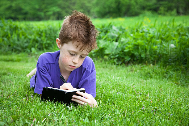 istock Happy Child Writing in a Journal Outside 469929869