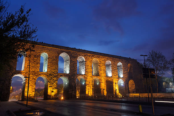 Istanbul, Turkey - November 14, 2017: Cars drive through arches at Valens Aqueduct on Atatürk Boulevard in Istanbul, Turkey. Completed in the late 4th century AD by Roman Emperor Valens, it was maintained and used by the Byzantines and later the Ottomans.