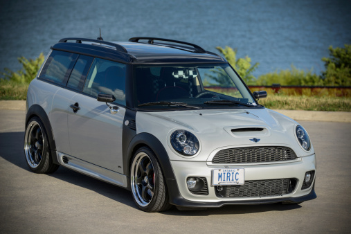 Toronto, Ontario, Canada- August 3, 2013. 2011 edition of Mini Cooper Clubman S small station wagon parked close to the curb at The Beach area of Toronto, near Lake Ontario. Car is customized with lowered suspension, racing brakes and wide low profile tires. Lake in the background.