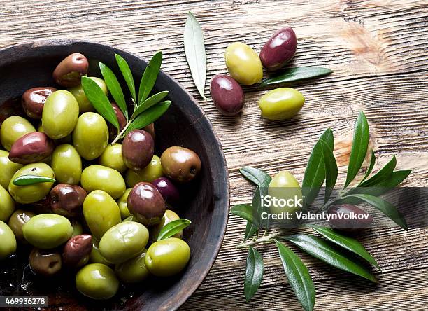 Wooden Bowl Full Of Olives And Olive Twigs Stock Photo - Download Image Now - 2015, Berry Fruit, Bowl