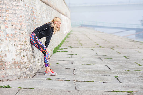 femme au repos après la séance d'exercice matinale - distance running jogging running fog photos et images de collection