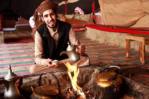 A Bedouin man in Wadi Rum desert welcoming visitors with Arabic Coffee