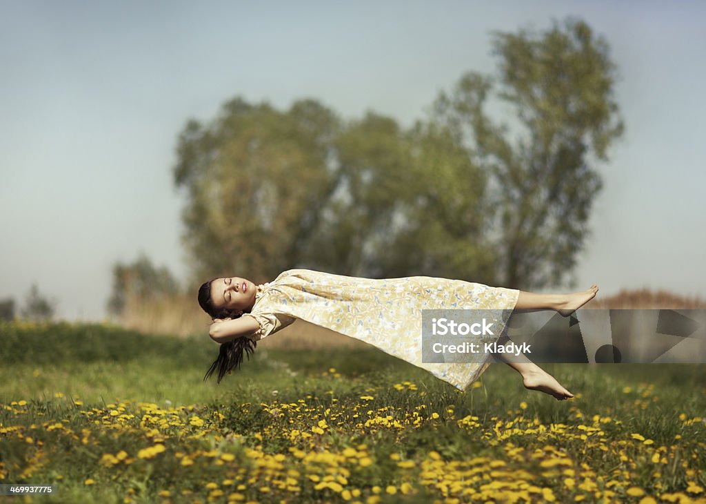 Levitation girls over the field. Girl in pajamas night flying over the field and dreams. Levitation Stock Photo