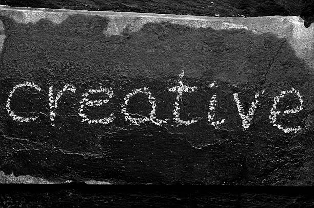 istock The word CREATIVE written with chalk on black stone. 469941386