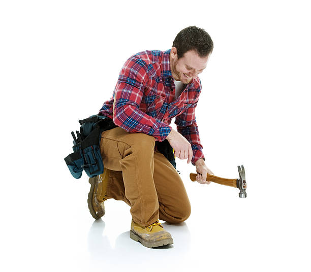 istock Smiling carpenter in action with hammer 469941419