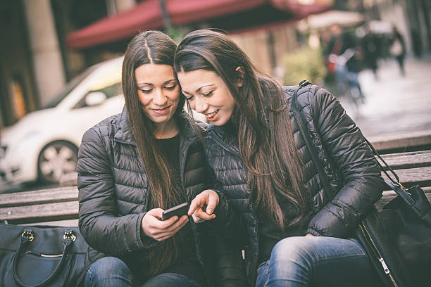 istock Two female twins looking at a smart phone 469943728
