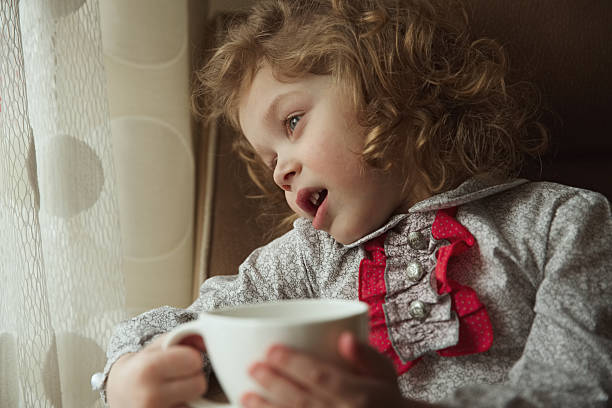 istock Beautiful curly-haired little girl with a cup 469948350