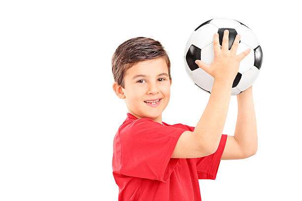 istock Young boy holding a soccer ball and looking at camera 469949927