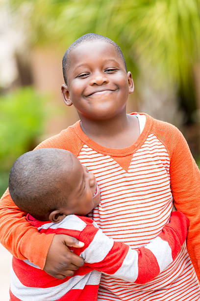 istock Happy little boy hugging big brother outdoors on sunny day 469951089