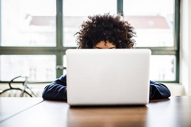 молодая женщина работает на ноутбуке в номер в стиле лофт площадью - прятать стоковые фото и изображения