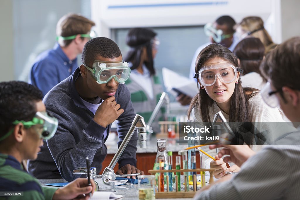 Group of multi-ethnic students in chemistry lab Young adult students of various ethnic backgrounds doing a chemistry experiment in class.  The students are all wearing protective safety goggles. Science Stock Photo