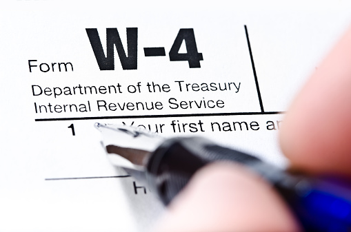 The process of filling out the W-4 form, shallow depth of field