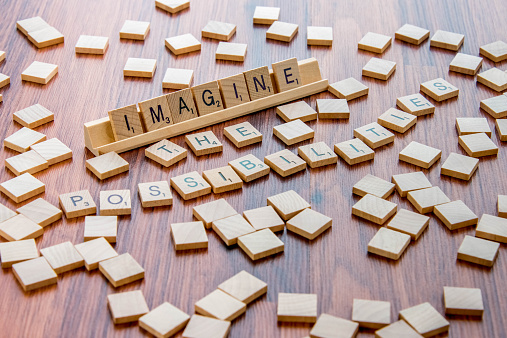 Houston, TX, USA - April 4, 2015: Scrabble Word Game wood tiles spelling IMAGINE THE POSSIBILITIES