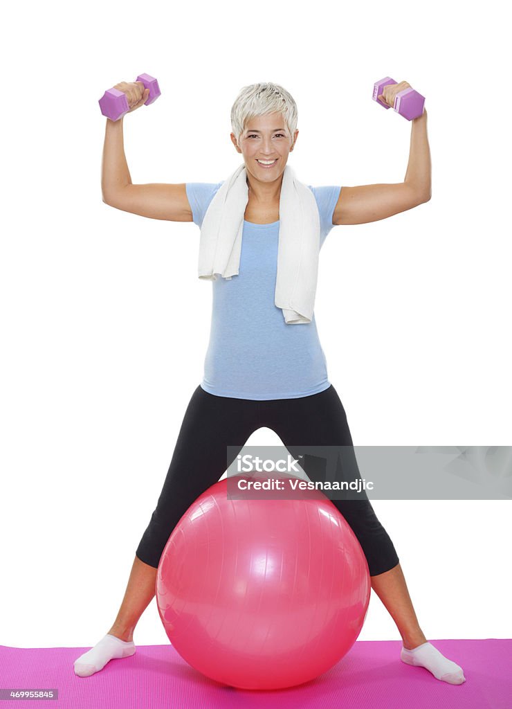 Mature woman with dumbbells on pilates ball White Background Stock Photo