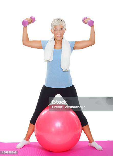 Mature Woman With Dumbbells On Pilates Ball Stock Photo - Download Image Now - White Background, One Woman Only, Senior Adult