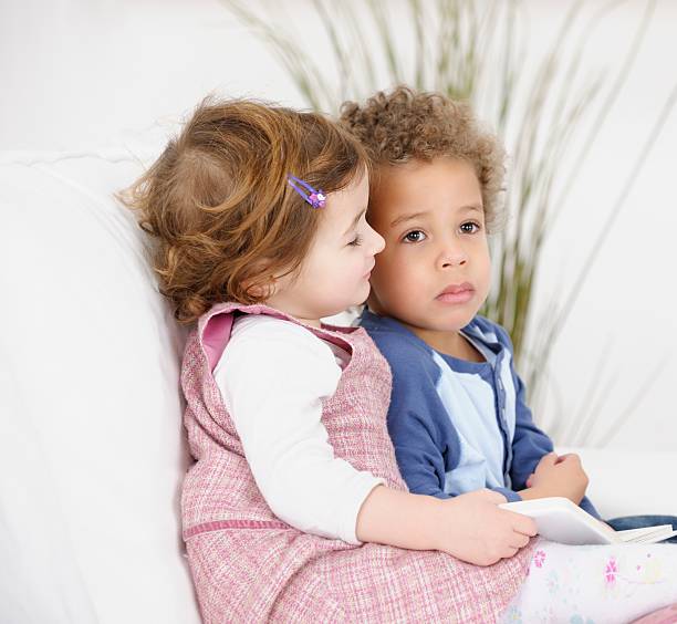 istock Toddlers Reading Book On The Couch/ Sofa 469956003