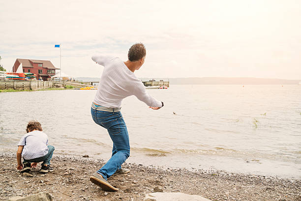 istock Dad and son making ricochets in water on northen beach. 469956449