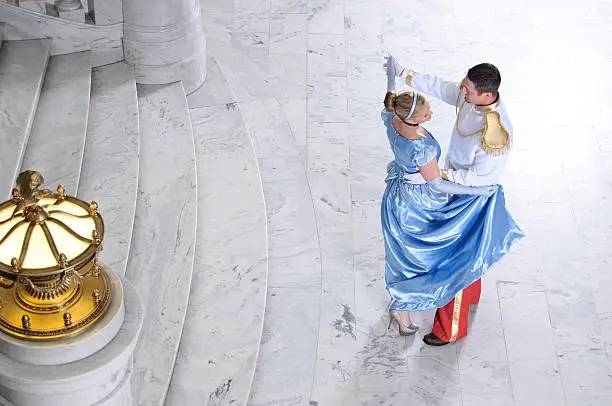 Cinderella and Prince Charming dancing at ball.