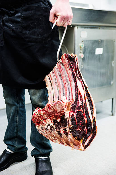 Butcher carrying a large cut of beef