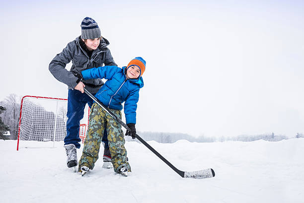 nauka gry ice hockey poza - ice skating ice hockey child family zdjęcia i obrazy z banku zdjęć