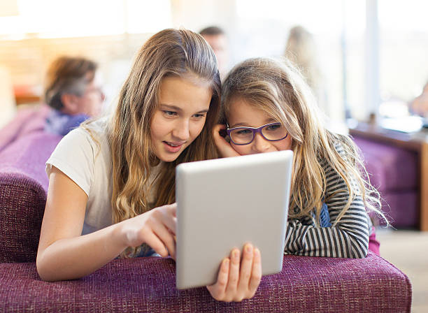 istock Two young girls using a digital tablet at home 469958221