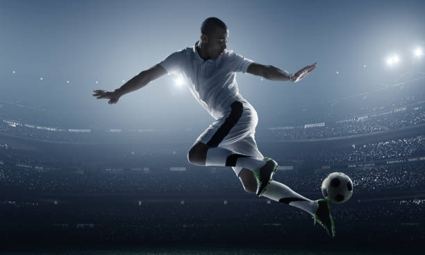 istock Athlete posed kicking a soccer ball in a stadium 469961428