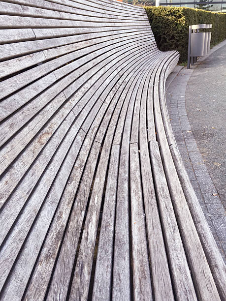 istock Long curved wooden bench outdoor with high backrest 469962664