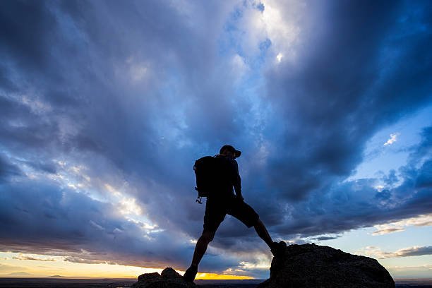 atardecer silueta hombre cielo dramático - travel destinations mountain hiking profile fotografías e imágenes de stock