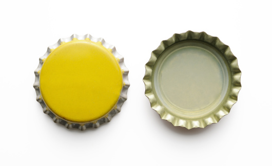 Close-up shot of two old metal yellow bottle cap isolated on white background with clipping path.