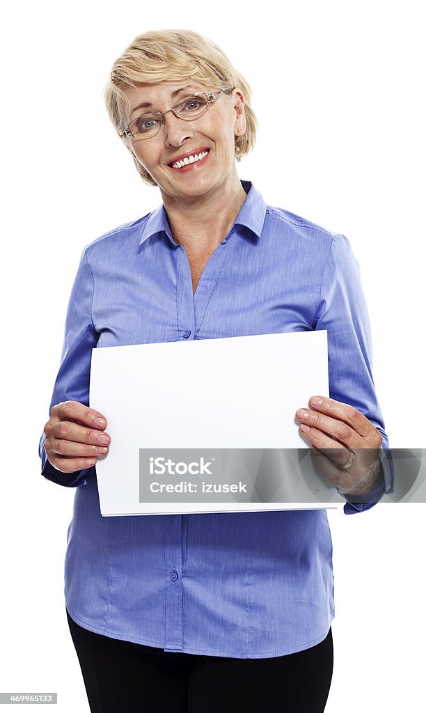 Senior businesswoman Portrait of smiling senior businesswoman holding a white piece of paper. Studio shot, white background. Holding Stock Photo