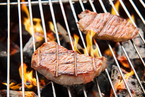istock pork steak cooking over flaming grill. 469966688