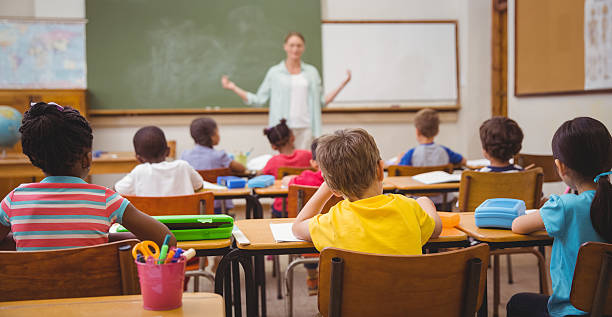 istock Pupils listening to their teacher at chalkboard 469967880