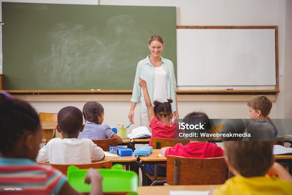 Pupil raising their hands during class Pupil raising their hands during class at the elementary school 20-29 Years Stock Photo