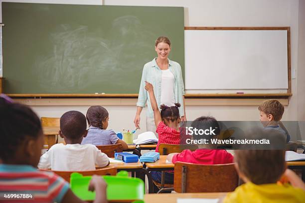 Pupil Raising Their Hands During Class Stock Photo - Download Image Now - 20-29 Years, 2015, 25-29 Years