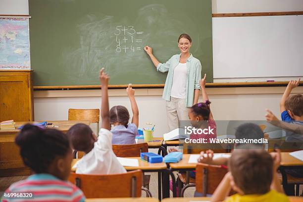 Pupils Raising Their Hands During Class Stock Photo - Download Image Now - 20-29 Years, 2015, 25-29 Years