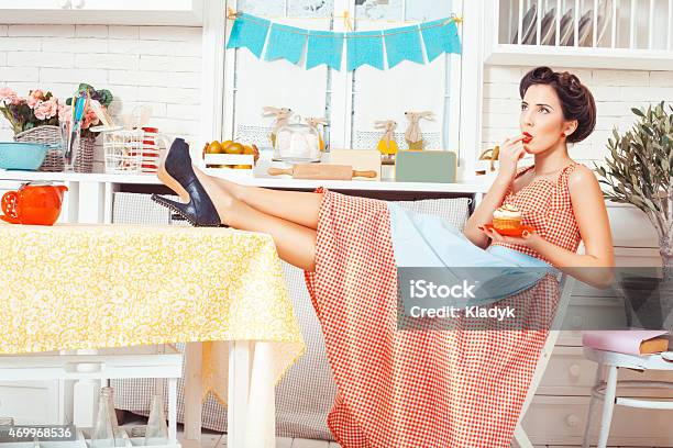 A Girl Licking Her Finger In The Kitchen Stock Photo - Download Image Now - Cake, Retro Style, Women