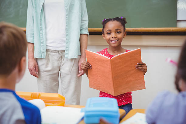 istock Cute pupils smiling at camera in classroom 469968654