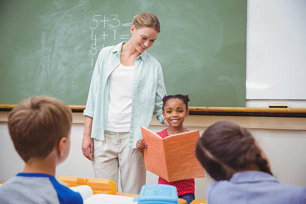 istock Cute pupils smiling at camera in classroom 469968656