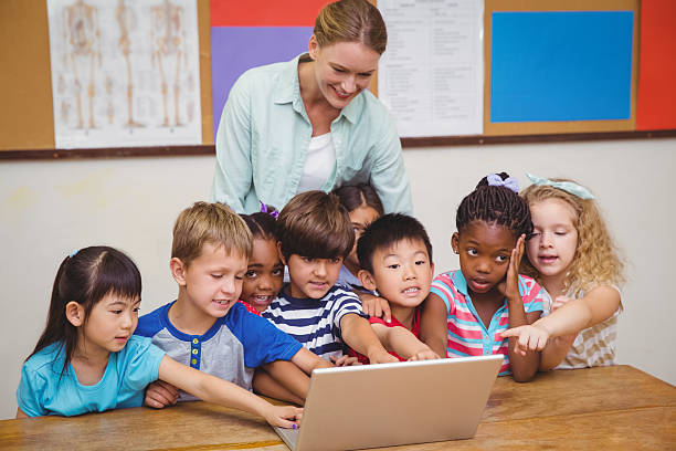 istock Teacher and pupils looking at laptop 469968848