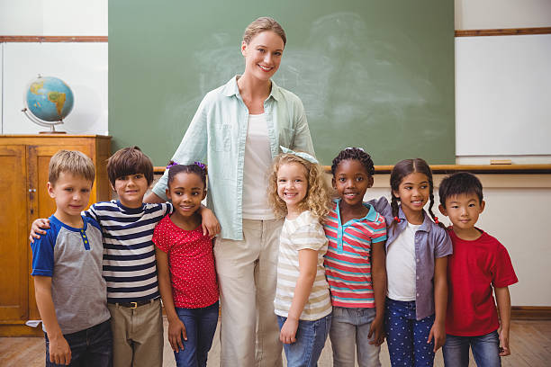 istock Cute pupils smiling at camera in classroom 469969158