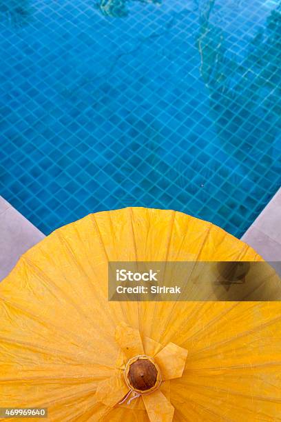 Yellow Umbrella At Blue Pool Stock Photo - Download Image Now - 2015, Art And Craft, Asia