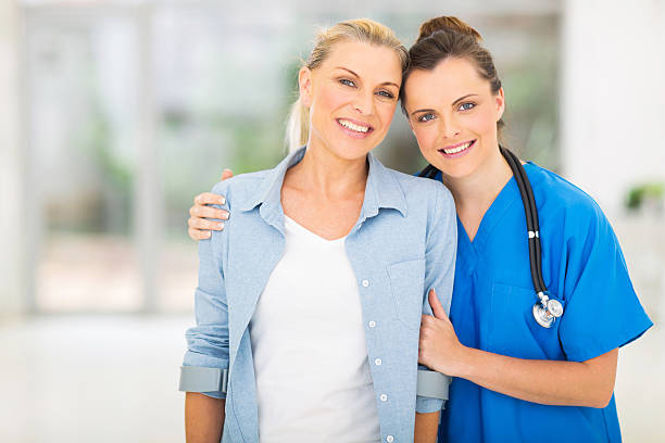 istock young nurse standing with disabled patient 469975908