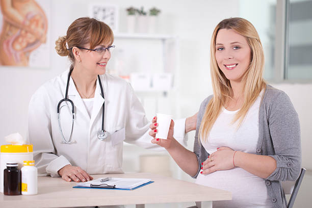 donna incinta in ambulatorio medico. - human pregnancy midwife healthcare and medicine visit foto e immagini stock