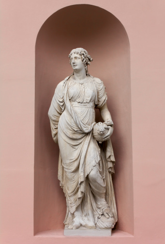 Neoclassic marble statue in its niche, portraying a woman holding a vase in her hand