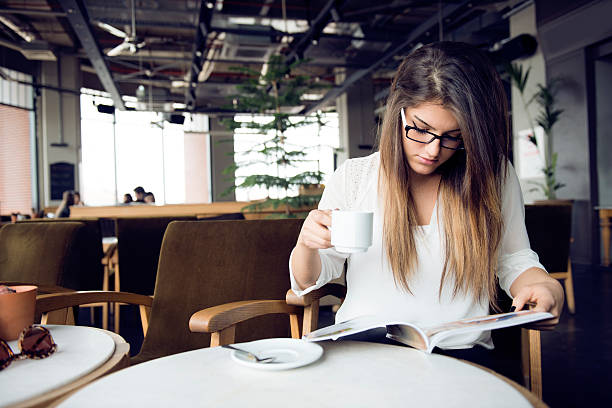 istock Woman reading magazine in cafe 469981191