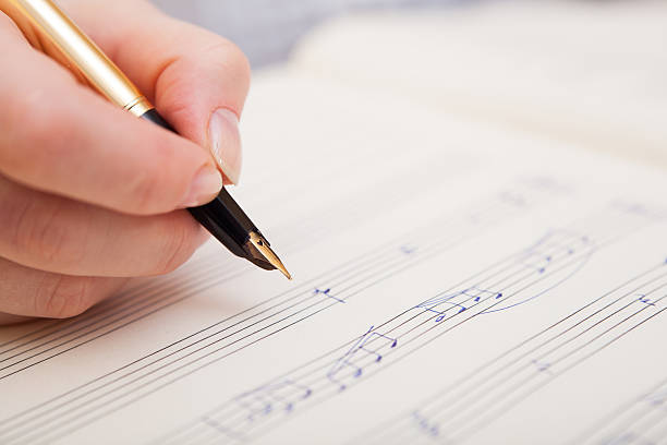 istock Hand with pen and music sheet 469991135